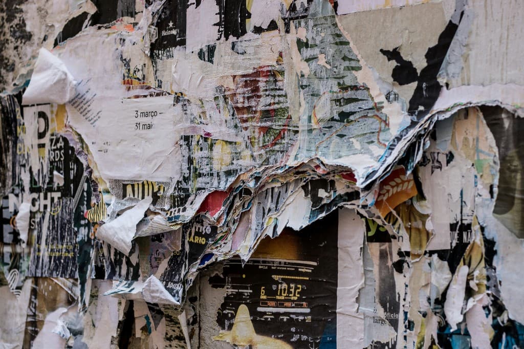 Layers of torn and peeling posters on a city wall